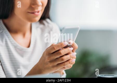 7/8-Ansicht von Frau, Beißen, Lippe und Sie ihr Smartphone Stockfoto