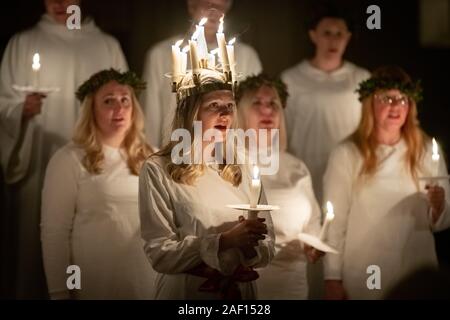 London, Großbritannien. 11. Dezember, 2019. Liv Palmblad, von Schweden, in der Rolle der Lucia, führt die Prozession während der Londoner Nordic Chor der traditionellen Skandinavischen ankta Lucia' Konzert in der St John's Church in der Nähe des Hyde Park. Der Service bietet ein Abendessen bei Kerzenschein Prozession der Vorsänger, geführt von einem Mädchen, Lucia, eine Krone trägt der Kerzen und eine rote Schärpe um ihre Taille. Credit: Guy Corbishley/Alamy leben Nachrichten Stockfoto