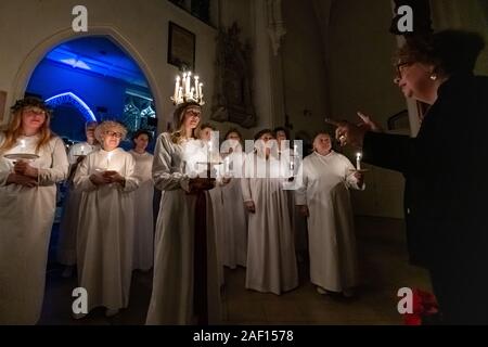 London, Großbritannien. 11. Dezember, 2019. Liv Palmblad, von Schweden, in der Rolle der Lucia, führt die Prozession während der Londoner Nordic Chor der traditionellen Skandinavischen ankta Lucia' Konzert in der St John's Church in der Nähe des Hyde Park. Der Service bietet ein Abendessen bei Kerzenschein Prozession der Vorsänger, geführt von einem Mädchen, Lucia, eine Krone trägt der Kerzen und eine rote Schärpe um ihre Taille. Credit: Guy Corbishley/Alamy leben Nachrichten Stockfoto