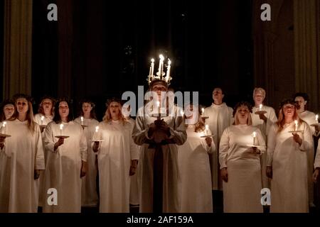 London, Großbritannien. 11. Dezember, 2019. Liv Palmblad, von Schweden, in der Rolle der Lucia, führt die Prozession während der Londoner Nordic Chor der traditionellen Skandinavischen ankta Lucia' Konzert in der St John's Church in der Nähe des Hyde Park. Der Service bietet ein Abendessen bei Kerzenschein Prozession der Vorsänger, geführt von einem Mädchen, Lucia, eine Krone trägt der Kerzen und eine rote Schärpe um ihre Taille. Credit: Guy Corbishley/Alamy leben Nachrichten Stockfoto