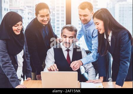 Gruppe von Multiethnischen Geschäftsleute trainning von Executive Senior Chef in modernen Büro mit Laptop. Start Team Meeting und Brainstorming, Stockfoto