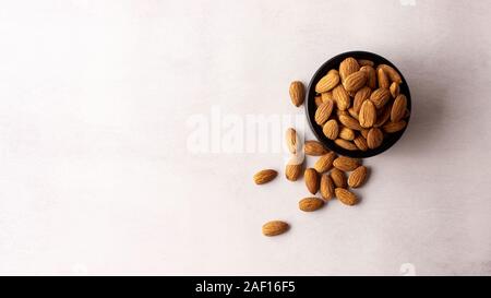 Die natürlichen und organischen Mandeln in einer schwarzen Schüssel, Ansicht von oben. Stockfoto