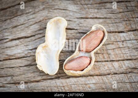 Geröstete Erdnüsse auf einer hölzernen Hintergrund/Shell Erdnuß in Tanks für Essen oder Snack Stockfoto