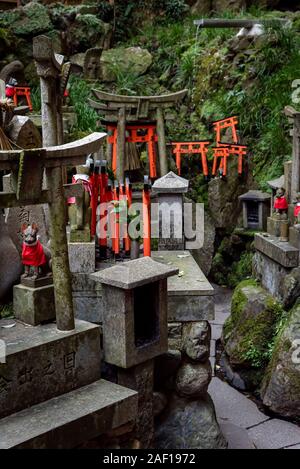 April, 12. 2019: Angebote der rote Torii Tore und Fox Skulpturen Fushimi-Inari. Kyoto, Japan Stockfoto