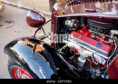 Elegante elegante schwarze alten Vintage Retro Auto mit großen gewölbten Kotflügel und Scheinwerfer und offenen kraftvoller Motor stehend auf einer improvisierten Straße exhibitio Stockfoto