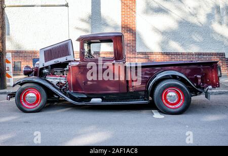 Eleganter Burgunder alte Vintage Retro Truck mit großen gewölbten Kotflügel und Scheinwerfer und Motorhaube öffnen Mit leistungsstarken Motor stehend auf einer improvisierten Straße ex Stockfoto