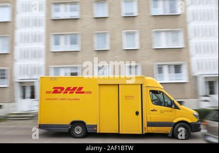 Halle, Deutschland. 11 Dez, 2019. Ein DHL Lieferung Fahrzeug fährt durch die Paulus Bezirk. DHL erwartet einen neuen Datensatz Anzahl der Pakete für die Tage vor Weihnachten. 11 Millionen Pakete pro Tag erwartet, wobei der Jahresdurchschnitt liegt bei 5 Millionen pro Tag. In Halle in der Weihnachtszeit bedeutet 52.000 Parzellen, die von 90 Lieferung Personal jede Woche an den vorderen Türen geliefert werden. Kredite: Jan Woitas/dpa-Zentralbild/dpa/Alamy leben Nachrichten Stockfoto