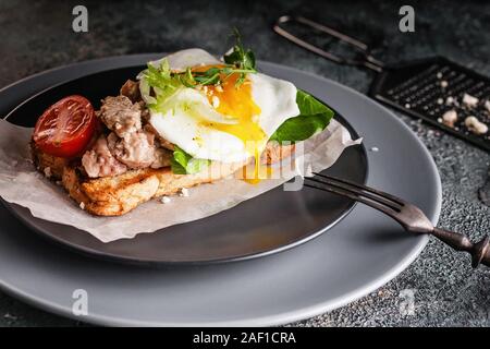 Köstliche Meeresfrüchte und Spiegelei Sandwich. Kopfsalat, Tomaten und Erbsen Sprossen. Ein gesundes und ausgewogenes Frühstück. Dorschleber Quelle von Vorteil Stockfoto