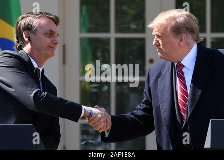 Washington, United States. 12 Dez, 2019. Präsident Donald Trump schüttelt Hände mit brasilianischen Präsidenten Jair Bolsonaro auf einer gemeinsamen Pressekonferenz im Rosengarten des Weißen Hauses in Washington, DC, am 19. März 2019. Foto von Pat Benic/UPI Quelle: UPI/Alamy leben Nachrichten Stockfoto