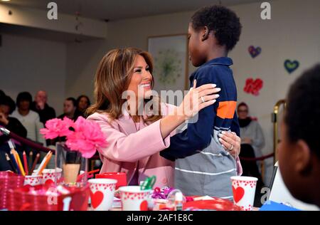 Washington, United States. 12 Dez, 2019. First Lady Melania Trump Umarmungen Amani, 13, von Mombasa, Kenia, mit Sichelzellanämie, wie die erste Dame erstellt Valentinstag Handwerk als sie Besuche bei kranken Kindern in der Inn auf dem Campus des National Institute of Health in Bethesda, Maryland am 14. Februar 2019. Foto von Kevin Dietsch/UPI Quelle: UPI/Alamy leben Nachrichten Stockfoto