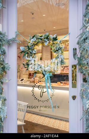 Weihnachtskranz an der Tür der Peggy Porschen Kuchenwerkstatt im Dezember. Kings Road, Chelsea, London, England Stockfoto