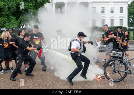 Washington Dc, USA. 12 Dez, 2019. U.S. Secret Service Agenten eine amerikanische Flagge, die auf Brand, der durch Mitglieder der Revolution und die Revolution Tour vor dem Weißen Haus in Opposition zu Präsident des Donald Trump alute nach Amerika "Independence Day Veranstaltung zu Ehren des Militärischen löschen, am 4. Juli 2019, Washington, DC Foto von Ken Cedeño/UPI Quelle: UPI/Alamy leben Nachrichten Stockfoto