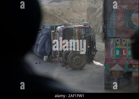 LEH, Jammu und Kashmir, Indien - 30. Juli 2011: Busfahrer beobachtet umgekippten LKW auf dem Leh-Manali Highway Stockfoto