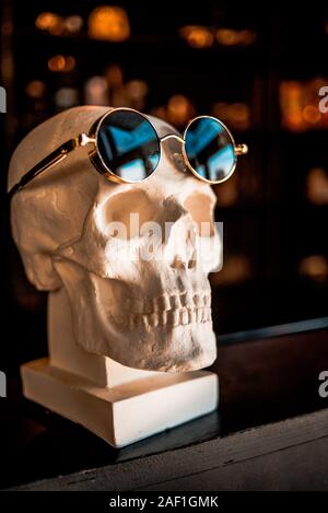 Schädel in Sonnenbrille ist im Regal Stockfoto