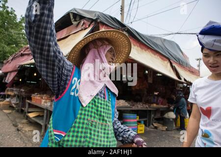 Bangkok, Thailand - 18. April 2011: Frau im mittleren Alter, die auf einem Straßenmarkt in Khlong Toei, einem armen Viertel am Stadtrand von Bangkok, arbeitet Stockfoto