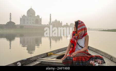 Eine Frau beobachten Sonnenuntergang über Taj Mahal (Agra, Indien) Von einer hölzernen Boot. Stockfoto