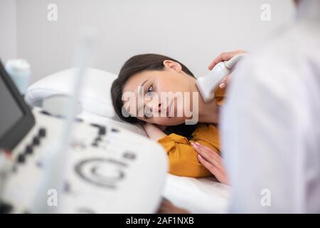 Arzt, der Ultraschall Sensor am Patienten Hals Stockfoto