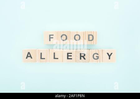 Blick von oben auf die Holzblöcke mit Worten Nahrungsmittelallergie auf Blau Stockfoto