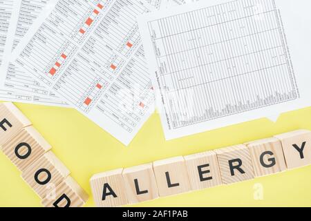 Blick von oben auf die Allergie test Ergebnisse in der Nähe von Holz- Bausteine isoliert auf Gelb Stockfoto