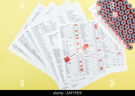 Blick von oben auf die Allergie test Ergebnisse in der Nähe von Röhrchen mit allergietest Schrift auf gelb isoliert Stockfoto