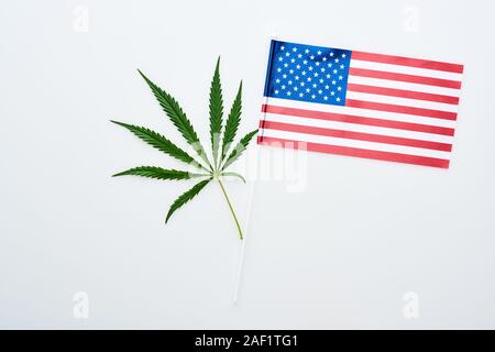 Blick von oben auf die Grüne cannabis Blatt in der Nähe der amerikanischen Flagge auf weißem Hintergrund Stockfoto