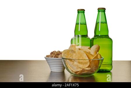 Bier in Flaschen mit Chips und Pistazien auf dem Tisch Stockfoto