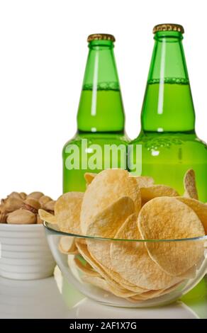 Bier in Flaschen mit Chips und Pistazien auf dem Tisch Stockfoto