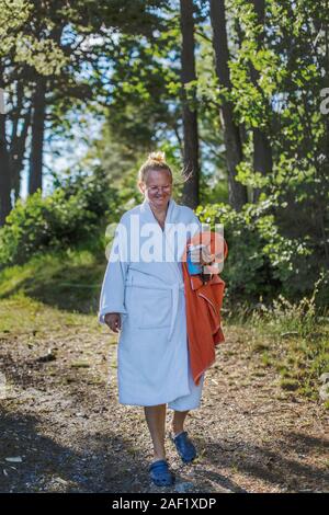 Frau trägt Morgenmantel holding Handtuch Stockfoto
