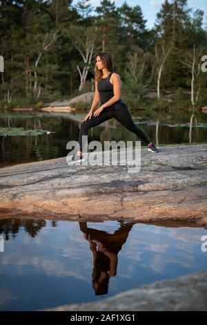 Frau am See Stretching Stockfoto