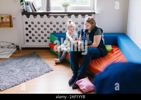 Lehrer lesen für Mädchen im Kindergarten Stockfoto