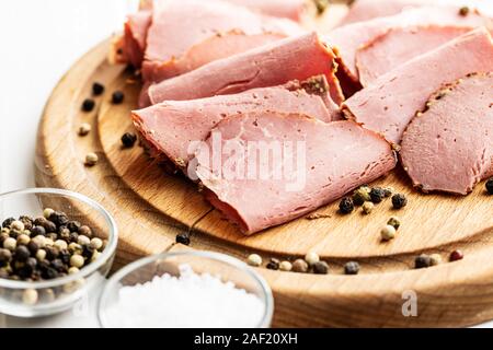 Roastbeef in Scheiben geschnitten. Lecker frisches Fleisch und ganze Pfeffer auf Schneidebrett. Stockfoto