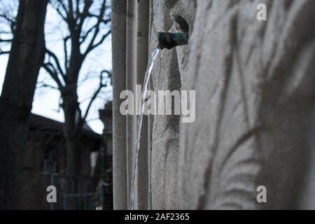 Eine Nahaufnahme von einem Brunnen Rohr mit Wasser fließt aus Stockfoto
