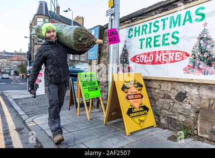 Edinburgh, Vereinigtes Königreich. 12. Dezember 2019 dargestellt: Maciek Wilk von canonmills Weihnachtsbäume ein Baum führt aus dem Wahllokal. Das Wahllokal Aktien ein Parkplatz mit einem Weihnachtsbaum Verkäufer. Credit: Rich Dyson/Alamy leben Nachrichten Stockfoto