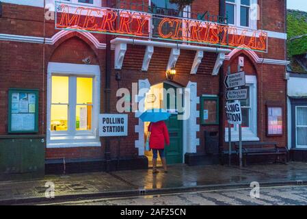 Fordingbridge, Hampshire, England, Vereinigtes Königreich, 12. Dezember 2019. Es ist Zeit, Ihre Farbe zu wählen. Die Abstimmung über die Parlamentswahlen 2019 in Großbritannien im Wahlkreis New Forest West ist im Gange. Ein Regenmantel und ein Regenschirm sind erforderlich, da heftiger Regen die Wähler am frühen Morgen am Wahlschalter des Rathauses begrüßt. Der Sitz wird von den Konservativen mit großer Mehrheit gehalten. Stockfoto