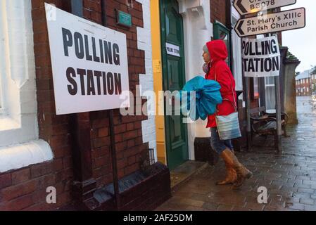 Fordingbridge, Hampshire, England, Vereinigtes Königreich, 12. Dezember 2019. Es ist Zeit, Ihre Farbe zu wählen. Die Abstimmung über die britischen Parlamentswahlen 2019 im Wahlkreis New Forest West ist im Gange. Ein Regenmantel und ein Regenschirm sind erforderlich, da heftiger Regen die Wähler am frühen Morgen am Wahlschalter des Rathauses begrüßt. Der Sitz wird von den Konservativen mit großer Mehrheit gehalten. Stockfoto