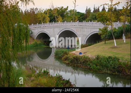 Wuxi, China - Oktober 2019: In einem alten, chinesischen gewölbten Steinbrücke in der Gonghuwan Wetlands Park, Provinz Jiangsu, China Stockfoto