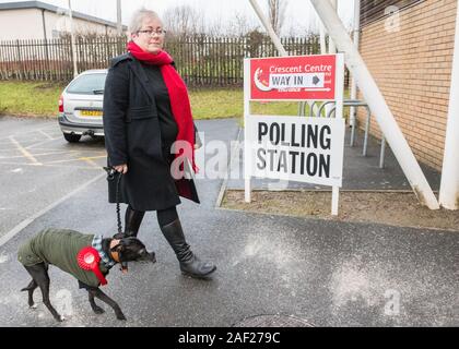 Mansfield, Nottinghamshire, England, UK. 12. Dezember, 2019. Labour Party bei den Parlamentswahlen Kandidatin für Mansfield Sonya Gemeinde mit ihrem Haustier Whippet legt früh in den regen ihre Stimme im Wahllokal zu werfen. Dieser parlamentarischen Sitz, der von Ben Bradley für die Konservative Partei, die von einer engen Spanne von 1.057 Stimmen gewonnen wurde, ist eine der wichtigsten Schlacht zwischen den beiden wichtigsten Parteien im 12. Dezember Parlamentswahlen, vor allem jetzt, da die Brexit Partei sind nicht die Anfechtung dieser Platz. Credit: AlanBeastall/Alamy leben Nachrichten Stockfoto