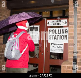 Kidderminster, Großbritannien. 12. Dezember, 2019. Trotz der eisigen Temperaturen und starker Regen, britischen Wähler scheinen in festlicher Stimmung zu sein, wie Sie die Elemente und Kopf zu Großbritanniens Wahllokalen ihre Stimmen in der heutigen Bundestagswahl cast sind mutig. Eine Dame trägt einen saisonalen Santa Hut zum Lächeln bringt und einige dringend benötigte Weihnachtsstimmung zu den Wählern in diesem Worcestershire Wahllokal. Quelle: Lee Hudson/Alamy leben Nachrichten Stockfoto