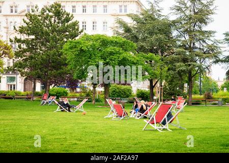 Menschen auf Liegestühlen in Sigmund Freud Park Vienna sitzen Stockfoto