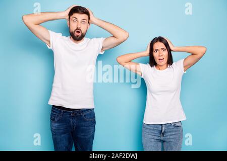 Portrait von frustriert negative schönen Ehegatten hören, schrecklich Informationen schreien Schreien trägt ein weisses T-Shirt denim jeans über Blau isoliert Stockfoto