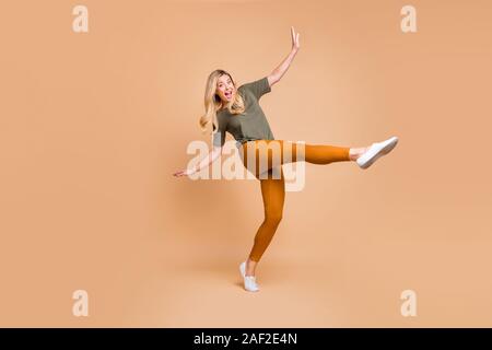 Volle Länge Körper Größe gedreht Foto fröhliche, positive niedlich charmant Schön reife energische Frau in Gelb grüne Hosen Hosen Aufregung auszudrücken Stockfoto