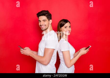 Foto von Paar von zwei Personen freundin Freund zusammen lächeln toothily sprechen miteinander per SMS Nachrichten tragen weiße t-shirt Stockfoto