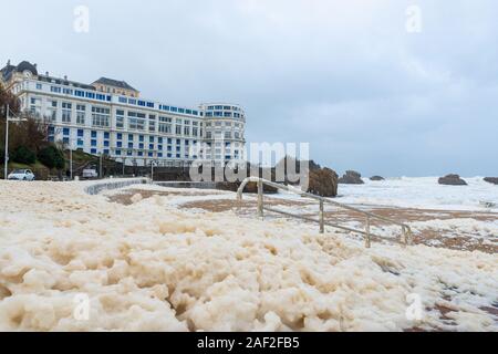 Schaum auf der Grande Plage Strand und seine Quay, Frankreich Stockfoto