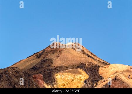 Krater des höchsten Gipfel hinter Formationen von Lavagestein an einem sonnigen und sehr klaren Tag in El Teide National Park. April 13, 2019. Santa Cruz De Tene Stockfoto