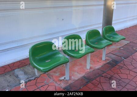 Closeup leeren grünen Plastikstühle an einer Bushaltestelle, hohe Betrachtungswinkel Stockfoto