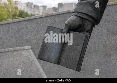 Nahaufnahme der Hand einer Statue hält ein offenes Buch Stockfoto