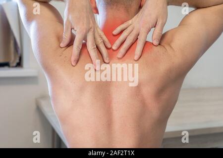 Man reibt sich die Hände mit einer schmerzhaften Bereich im oberen Rücken. der Mensch Leiden, Nacken- und Schulterschmerzen. Stockfoto
