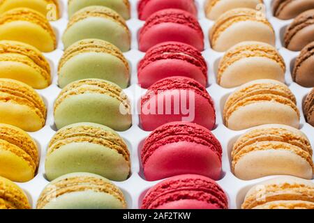 Klassische französische Dessert. Bunte macarons in hellem rosa grün gelb Creme Schokolade in einer Kiste gestapelt, selektiver Fokus Stockfoto