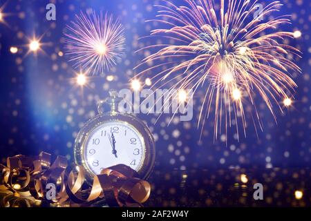 Silvester um Mitternacht - alte Uhr mit Feuerwerk und Weihnachtslichter Stockfoto