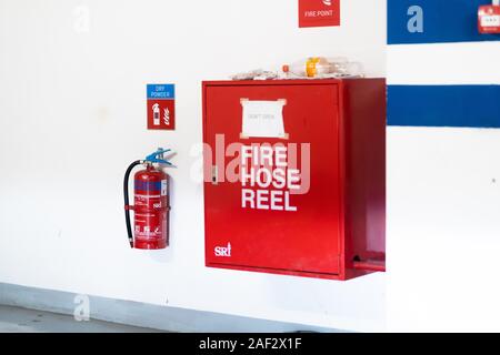 Schläuche verpackt innerhalb der roten Not-Aus-Kasten an der Wand Stockfoto